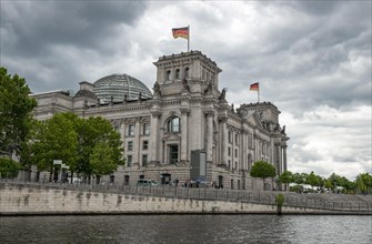 Reichstag building with waving German flag on the Spree