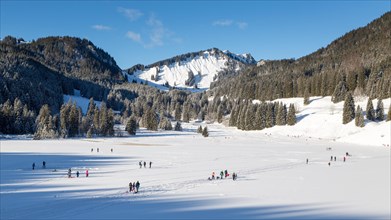 Frozen Spitzingsee in winter with people