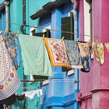 Towels drying on line in front of colorful houses