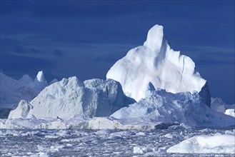 Massive icebergs floating in the Arctic sea in the Disko Bay
