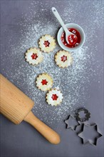 Spitzbuben cookies with dough roll and bowl with redcurrant jelly