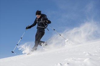 Woman with snowshoes walking through snow
