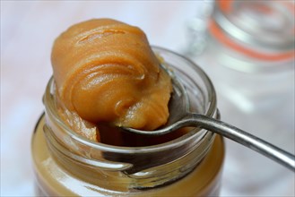 Salted caramel cream on spoon with glass