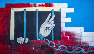 Mural Chained Hand Making Peace Signs from Prison