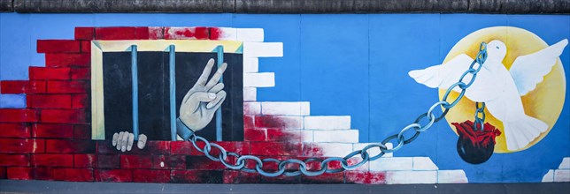 Mural Angekettete Hand makes peace sign from prison with peace dove
