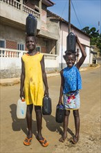 Friendly girls carrying a water canister