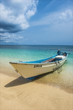 Little motorboat in the turquoise waters of Banana beach