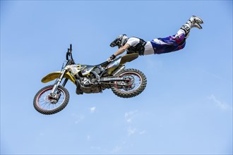 Motocross rider jumping in front of blue sky