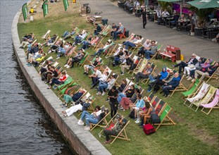 People sitting in deck chairs at the Spree