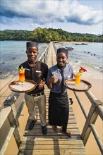 Waiters serving cocktails on a long wooden pier in the Bom Bom Resort