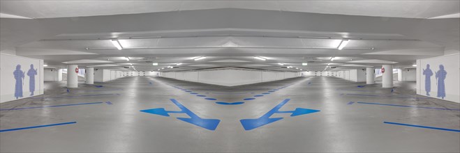 Photomontage of an empty underground car park with blue arrows on the ground