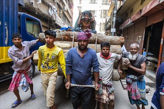 Men carrying a huge load through the bazaar