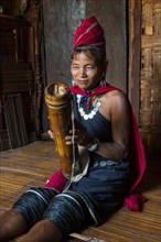 Old Kayah woman playing local instrument