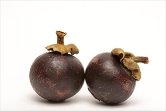 Two mangosteen isolated on a white background