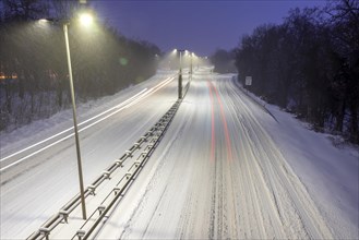 Snowy city highway with light traces of cars