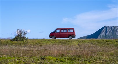 Red VW bus stands in the landscape
