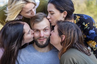 Man surrounded by four girls