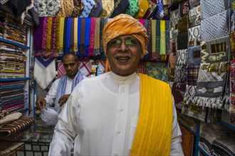Traditional dressed man in a cloth shop