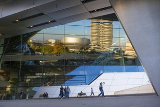 BMW Tower and BMW Museum reflected in the BMW Welt customer experience and exhibition facility building