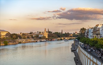 View over the river Rio Guadalquivir with promenade at Calle Betis in Triana and Torre del Oro