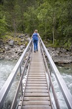 Hiker on wooden bridge over the river Driva