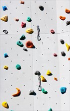 Handles hooks and eyes on a climbing wall