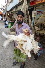Man holding many chickens