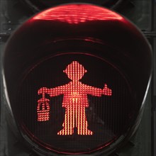 Red pedestrian traffic light man as miner with pit lamp