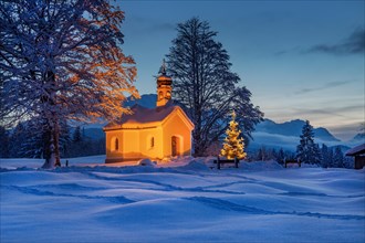 Maria Rast chapel on the hunchback meadows with Christmas tree and Wetterstein mountains at dusk
