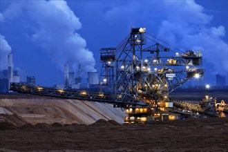 Opencast lignite mine with stacker and power plants in the evening