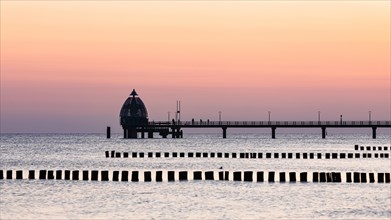 Groyne and diving bell with pier at the beach of Zingst at sunrise