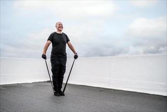 A man exercising with rubber band on the rooftop during lockdown