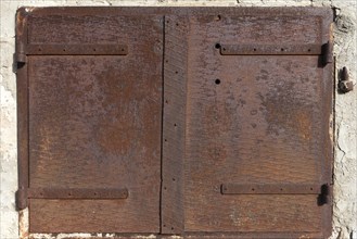 Rusty iron hatch on a house