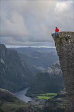 Single person sitting on the edge at the rock plateau