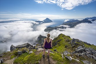 Hiker looking over mountain landscape in clouds