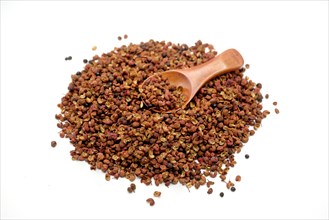 Sichuan peppercorns with a wooden spoon against a white background