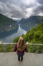 Young woman looking over the fjord at Ornesvingen viewpoint