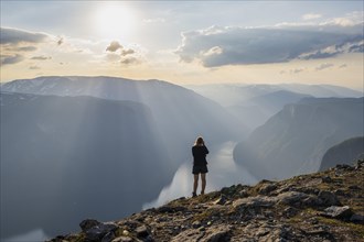 Hiker taking pictures of fjord landscape