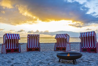 Beach chairs and fire bowl at sunrise at the big beach of Thiessow