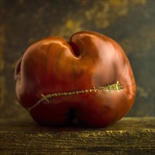 Deformed red tomato on brown background