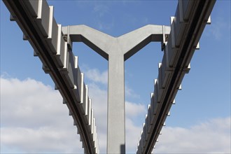 Steel and concrete monorail track against blue sky