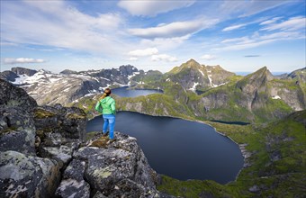 Young woman looking over mountain landscape with lake Tennesvatnet and Krokvatnet