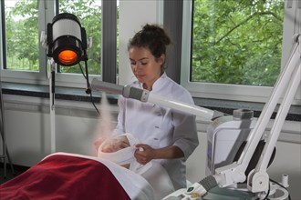 Facial compress in combination with the steamer and a Hydrosun coloured light therapy in practical lessons. Training as a beautician at the vocational school