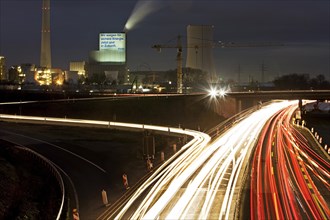 Light traces in the evening on the motorway A 43 with the Steag power plant Herne in the background