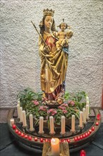 Figure of the Virgin Mary with baby Jesus and sacrificial candles