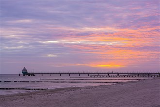 Groyne and diving gondola with pier at the beach of Zingst at sunrise