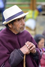 Old indigenous man with hat leaning on a stick