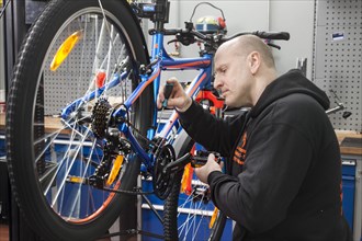 Bike mechanic in the bike workshop during an inspection on a mountain bike