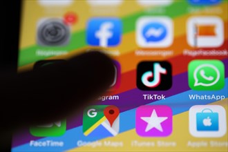 Finger about to press on the TikTok app icon on a smartphone
