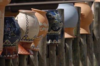 Wooden fence with painted clay jugs